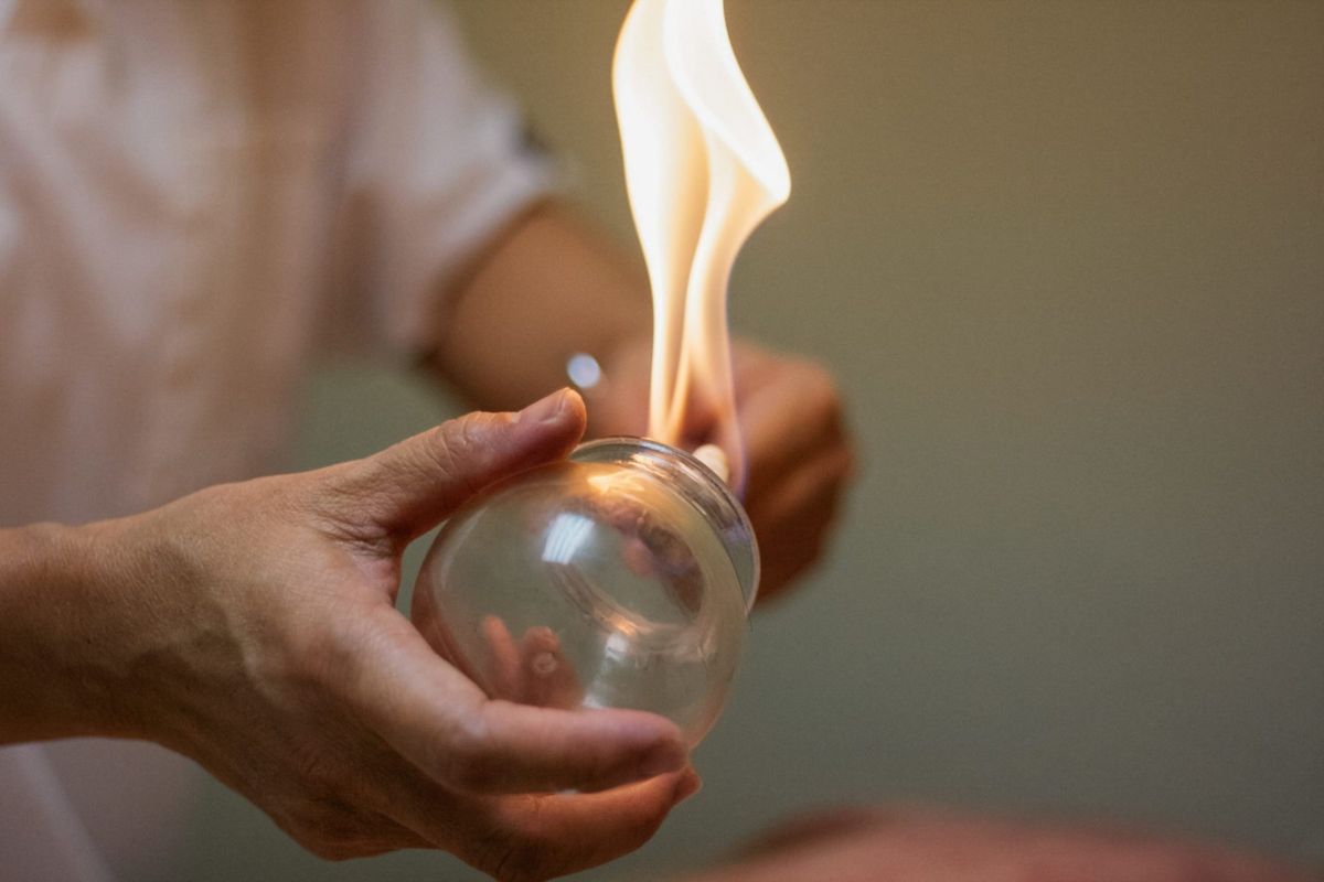Jude holding a glass cup above a flame